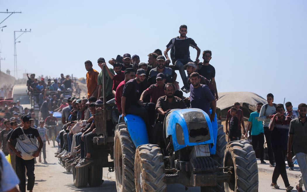 Palestinians make their way along Al-Rashid road toward Gaza City from Nuseirat in the central Gaza Strip on October 10, 2025. Israeli forces declared a ceasefire and withdrew from some positions in Gaza on October 10, as thousands of displaced Palestinians began to trek home and the families of October 7 hostages awaited news. Israeli prime minister's office said that the government had "approved the framework" of a hostage release deal with Hamas, as both sides edged closer to ending more than two years of hostilities in Gaza. (Photo by Bashar TALEB / AFP)