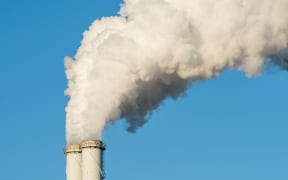 The pipe of a coal power plant with white smoke as a global warming concept.