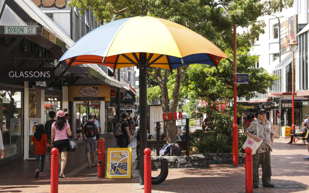Summer in Wellington, Cuba Street. A man seeks shelter from the sun.