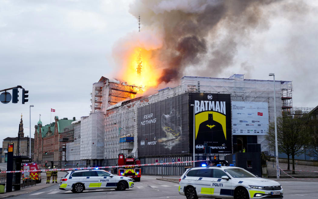 Police cars park as flames engulf the Copenhagen's Stock Exchange building, in Copenhagen, on April 16, 2024. (Photo by Ida Marie Odgaard / Ritzau Scanpix / AFP) / Denmark OUT