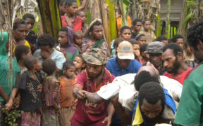 A husband and father is carried to his grave after dying in the bush when he went to make sago. He was hungry and weak and trying to feed his family.