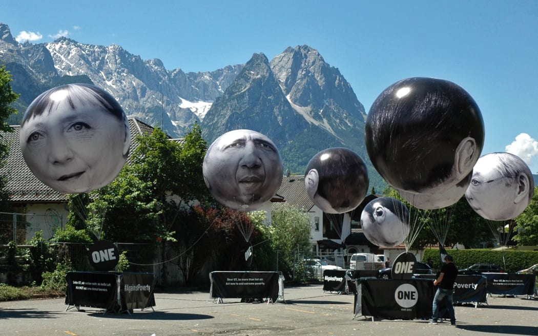 Balloons with faces of leaders at the G7 summit.