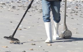 Man with metal detector on beach
