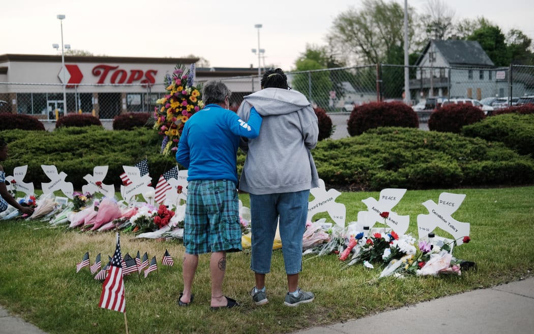 BUFFALO, NEW YORK - MAY 20: People gather at a memorial for the shooting victims outside of Tops market on May 20, 2022 in Buffalo, New York. 18-year-old Payton Gendron is accused of the mass shooting that killed 10 people at the Tops grocery store on the east side of Buffalo on May 14th and is being investigated as a hate crime.   Spencer Platt/Getty Images/AFP (Photo by SPENCER PLATT / GETTY IMAGES NORTH AMERICA / Getty Images via AFP)