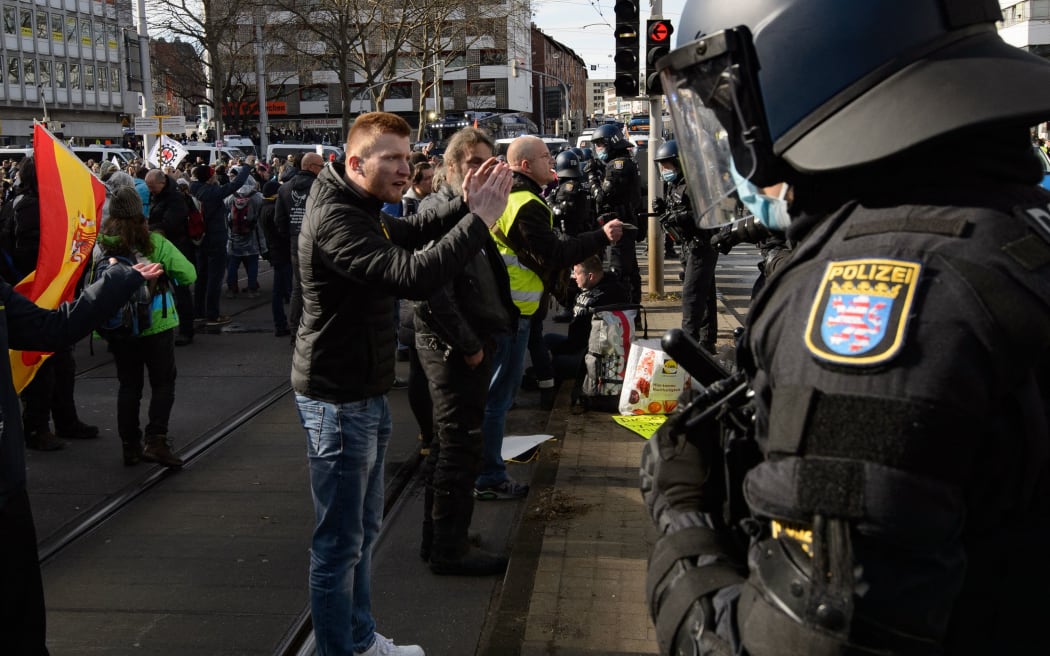 20 March 2021, Hessen, Kassel: Police forces stand in front of participants at a rally under the motto "Free Citizens Kassel - Basic Rights and Democracy".