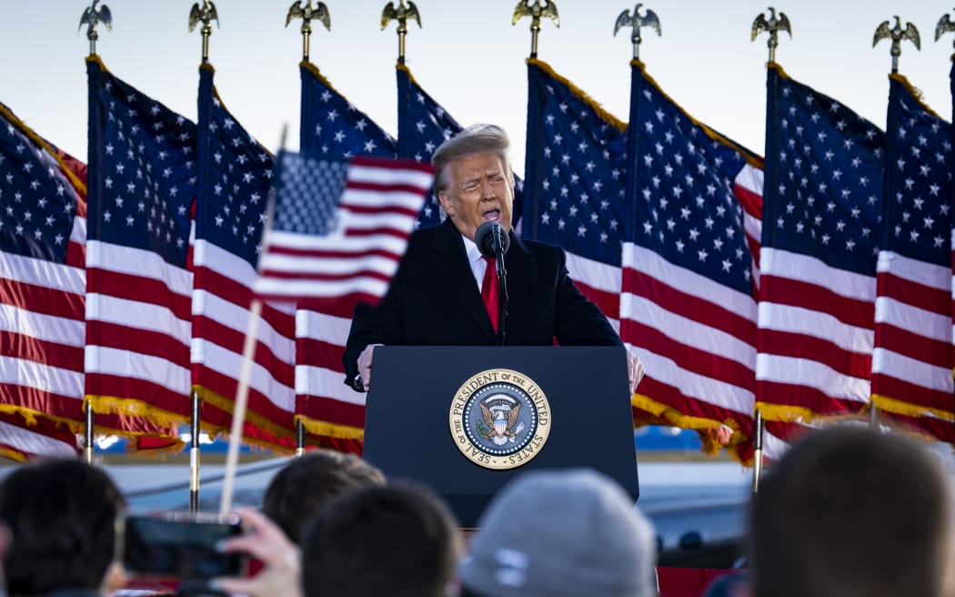 President Donald Trump speaks to supporters at Joint Base Andrews before boarding Air Force One for his last time as President.