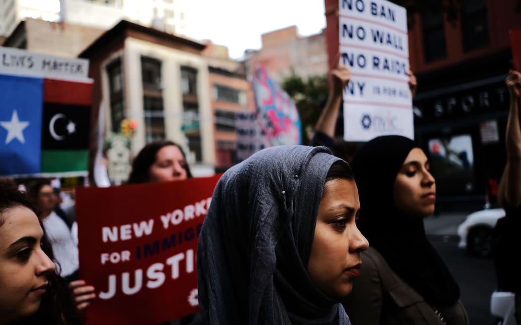 Recent Immingrants join activists for an evening protest in Manhattan in the hours before the revised version of President Donald Trump's travel ban came into effect.