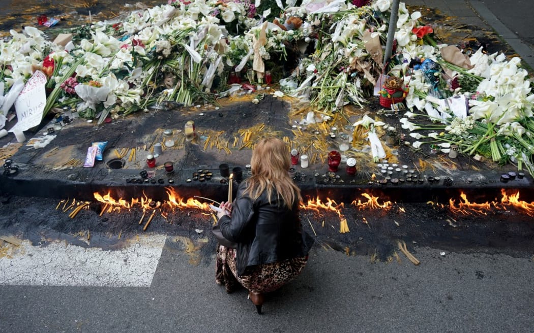 A woman lights candles outside the Vladislav Ribnikar elementary school in Belgrade, Serbia, two days after a 13-year-old suspect shot dead eight fellow students and a security guard after allegedly drawing up a kill list.