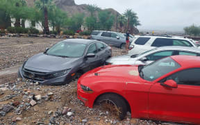 Stranded visitors and park staff stand by some of the sixty cars immobilised by debris from the monsoonal rain at the Inn at Death Valley, in Death Valley National Park, California. The intense and rare rainfall in California's famous Death Valley on on 5 August, 2022, caused major flooding, trapping approximately 1,000 people inside the national park.