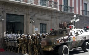 An armored vehicle and military police form outside the government palace at Plaza Murillo in La Paz, Bolivia, on Wednesday, 26 June, 2024.
