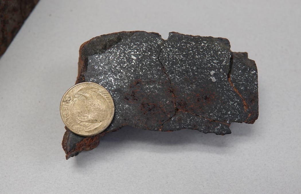 Section of Kimbolton meteorite shows its composition. The coin gives the context of its size.