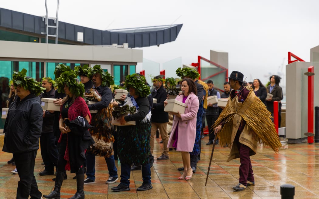 Iwi delegation arrive on to Rongomaraeroa, carrying the tūpuna and karāpuna through the waharoa and Ranginui doors at Te Papa’s repatriation pōwhiri.