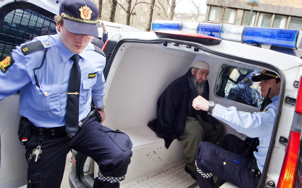 Mullah Krekar (C), sits in a police van after his arrest March 2012 at his Oslo appartment by Norwegian police