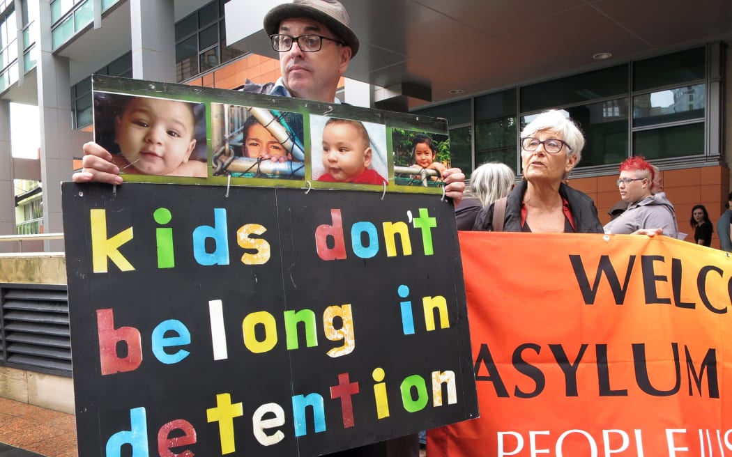 People hold placards at a protest outside an immigration office in Sydney on February 4, 2016.