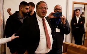 Israel's far-right National Security Minister Itamar Ben Gvir enters the district courtroom in Tel Aviv and addresses the media before the start of Prime Minister Benjamin Netanyahu's hearing on December 10, 2024. - Netanyahu, the first sitting prime minister of Israel to face a criminal trial, is expected to testify for the first time when his corruption case resumes on December 10 on charges of bribery, fraud and breach of public trust in three separate cases. (Photo by Menahem Kahana / POOL / AFP)