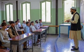 Boys attend their class at Istiklal school in Kabul on September 18, 2021. (Photo by BULENT KILIC / AFP)