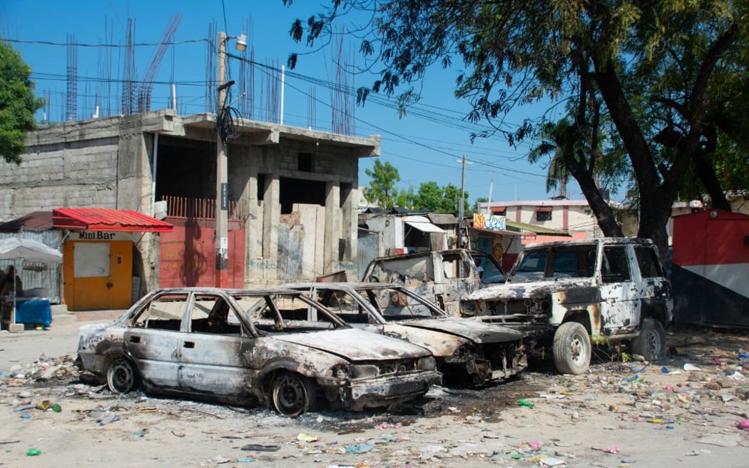 Charred vehicles remain parked as gang violence escalates in Port-au-Prince, Haiti, on March 9, 2024. Sporadic gunfire rang out in Port-au-Prince late March 8, an AFP correspondent there heard, as residents desperately sought shelter amid the recent explosion of gang violence in the Haitian capital. (Photo by Clarens SIFFROY / AFP)