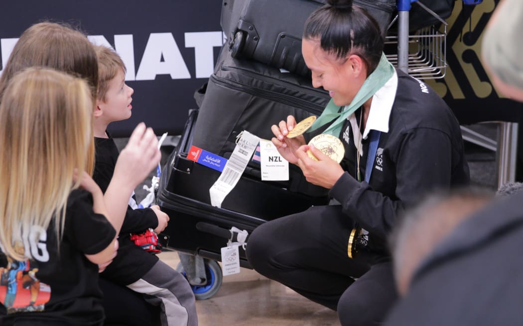 Tyla King shows her medals to young fans