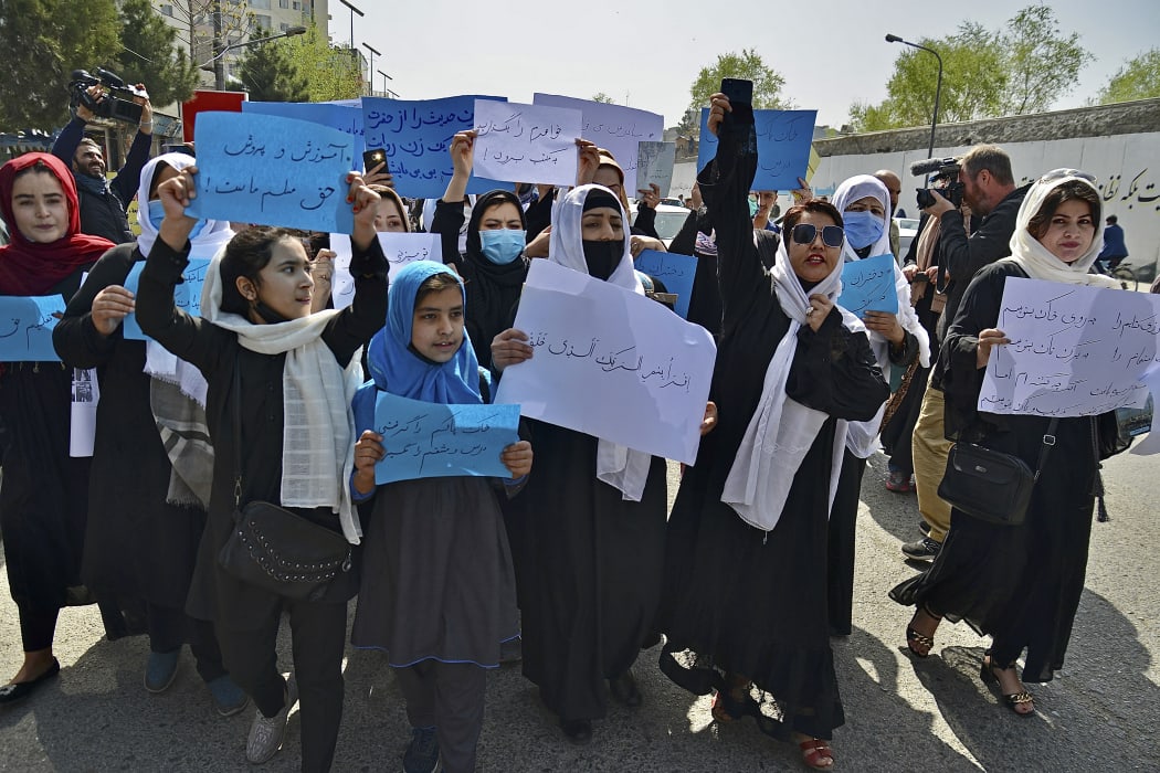 Afghan women and girls protesting in front of the Ministry of Education in Kabul, demanding schools be reopened for girls.