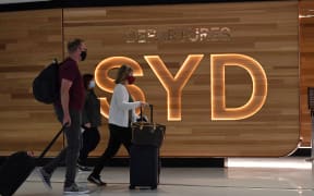 Passengers walk to board a plane at Sydney International Airport on 1 November 2021.