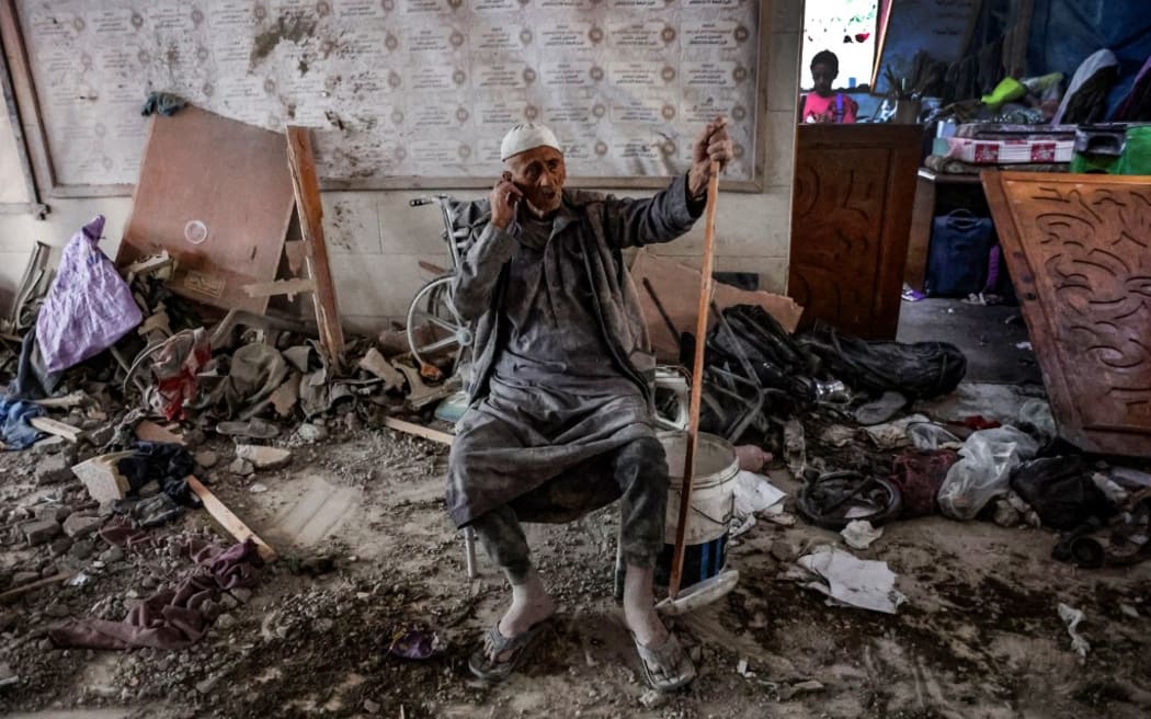 An elderly man sits amid the rubble inside a school used as a temporary shelter for displaced Palestinians in Gaza City, after it was hit by an Israeli strike on August 10, 2024, that killed more than 90 people, as the conflict between Israel and the Hamas movement continues. (Photo by Omar AL-QATTAA / AFP)