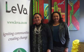 Both stand by organisation banner in front of bright wall art