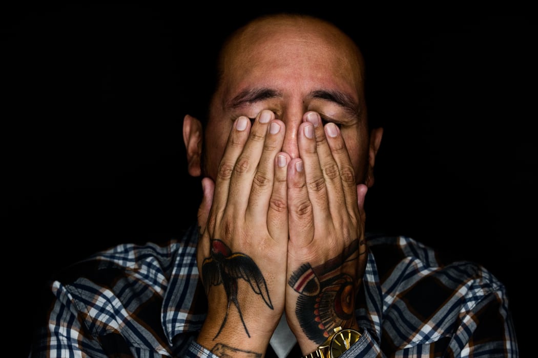 man covering his eyes
