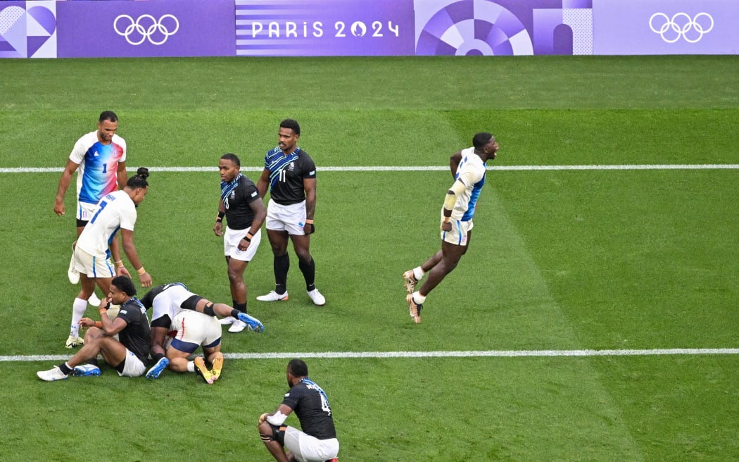 France's Andy Timo (R) celebrates during the men's gold medal rugby sevens match between France and Fiji during the Paris 2024 Olympic Games at the Stade de France in Saint-Denis on July 27, 2024. (Photo by Odd ANDERSEN / AFP)