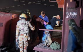 A soldier (L) works to evacuate freed train passengers at the Mach railway station, which has been turned into a makeshift hospital, after Pakistani security forces freed nearly 80 passengers following a security operation against armed militants who ambushed the train in the remote mountainous area, in Mach, southwestern Balochistan province on March 11, 2025. Pakistani troops freed dozens of train passengers taken hostage by armed militants of the Baloch Liberation Army (BLA), a separatist group behind rising violence in the province which borders Afghanistan and Iran, after gunmen forced a train to a halt in a remote, mountainous area of Balochistan province in the afternoon of on March 11, 2025. (Photo by Banaras KHAN / AFP)