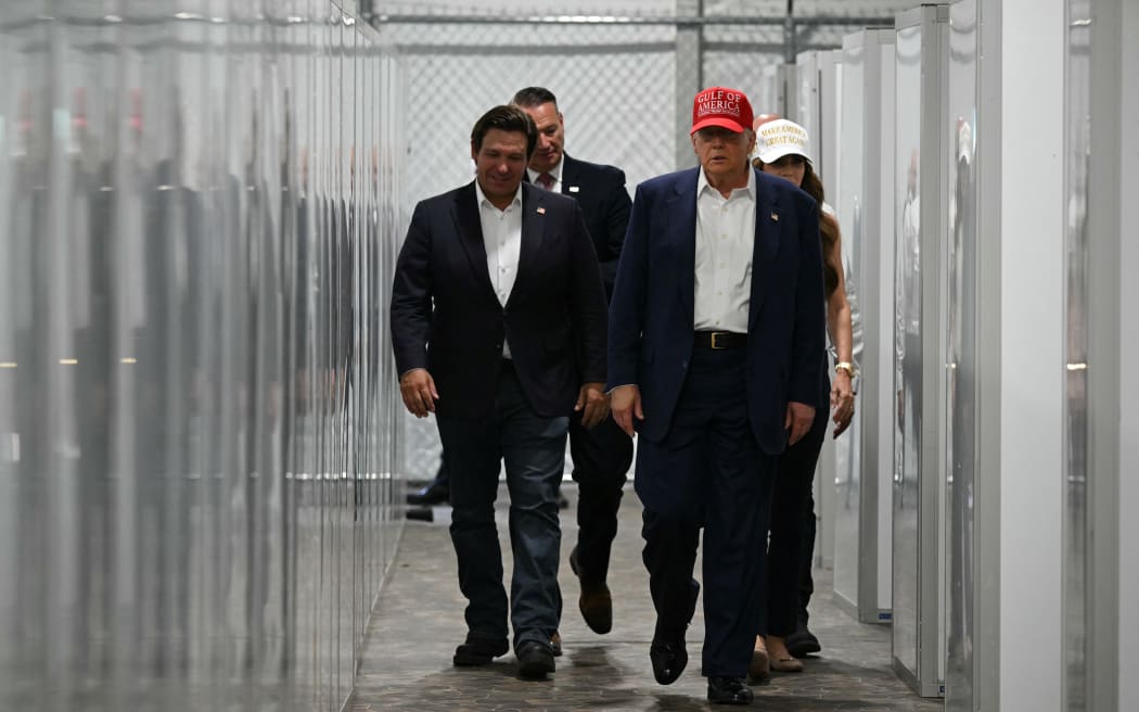 Florida Governor Ron DeSantis (L), US President President Donald Trump (C) and Homeland Security Secretary Kristi Noem (R) tour a medical facility during a visit to a migrant detention center, dubbed "Alligator Alcatraz," located at the site of the Dade-Collier Training and Transition Airport in Ochopee, Florida on July 1, 2025. President Trump is visiting a migrant detention center in a reptile-infested Florida swamp dubbed "Alligator Alcatraz." Trump will attend the opening of the 5,000-bed facility -- located at an abandoned airfield in the Everglades wetlands -- part of his expansion of deportations of undocumented migrants, his spokeswoman said. (Photo by ANDREW CABALLERO-REYNOLDS / AFP)