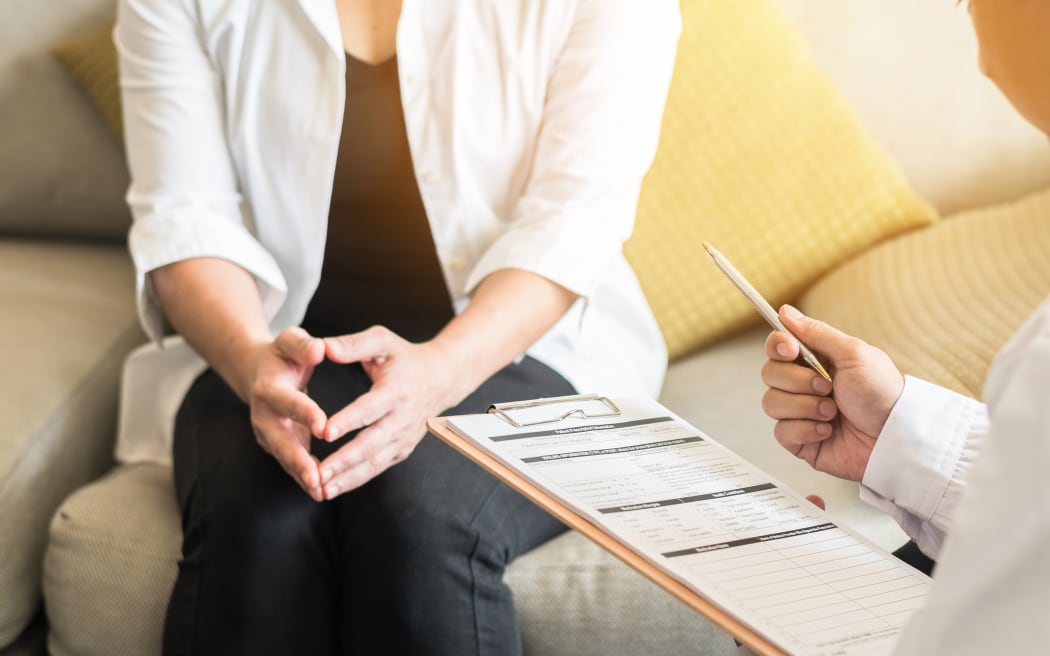 Doctor (gynecologist or psychiatrist) consulting and examining woman patient's health in medical clinic or hospital health service center