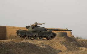 A Pakistani army tank stands at the Pakistan-Afghanistan border in Chaman on February 27, 2026, following overnight cross-border fighting between the two countries. Pakistan bombed major cities in Afghanistan including the capital Kabul on February 27, with Islamabad's defence minister declaring the neighbours at "open war" following months of tit-for-tat clashes. AFP journalists in Kabul and Kandahar heard blasts and jets overhead, as Pakistan launched air strikes on the Afghan capital and southern power base of the Taliban authorities. (Photo by Abdul BASIT / AFP)