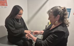 Macy Te Whaiti having her temperature checked by registered nurse Tina Carrell