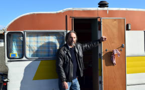 Traveller Beck Ritchie relaxes outside his caravan parked in the Ocean View Recreation Reserve freedom camping site last week,