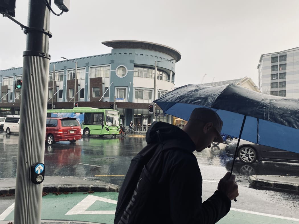 A pedestrian in central Auckland after strong winds battered the region.