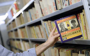 A vynil LP of US jazz musician Louis Armstrong and singer Ella Fitzgerald is taken from a rack on October 19, 2011 in Paris at the music library of the public media group Radio France.  AFP PHOTO MIGUEL MEDINA (Photo by MIGUEL MEDINA / AFP)