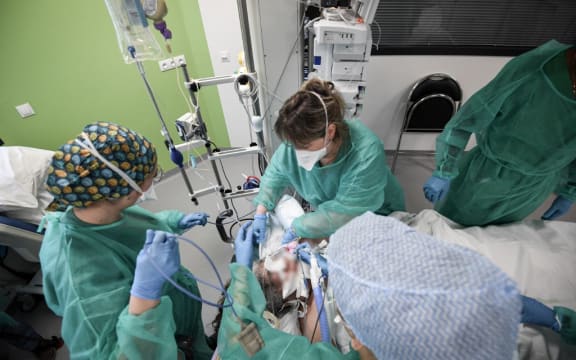 Nurses tend to a Covid-19 patient at the intensive care unit of the Delafontaine AP-HP hospital in Saint-Denis, outside Paris, on December 29, 2021.