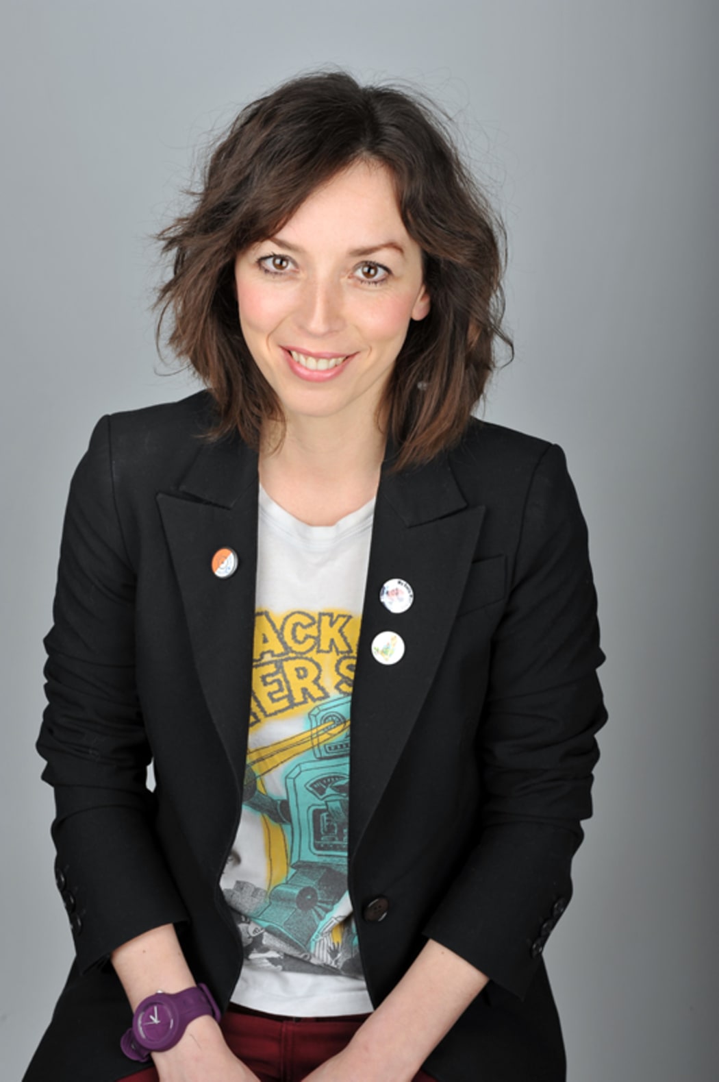 a portrait of Bridget Christie. She wears a blazer and a gig tshirt.