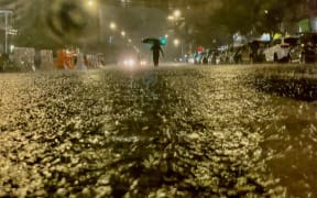 A person makes their way in rainfall from the remnants of Hurricane Ida on September 1, 2021, in the Bronx borough of New York City.