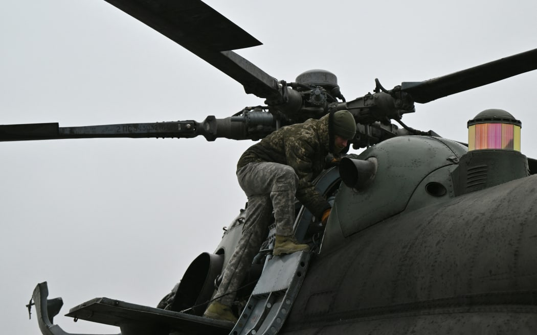 A Ukrainian serviceman of an Army Aviation Brigade prepares a Mi-8 helicopter to fly in the Donetsk region on December 7, 2023, amid the Russian invasion of Ukraine. (Photo by Genya SAVILOV / AFP)