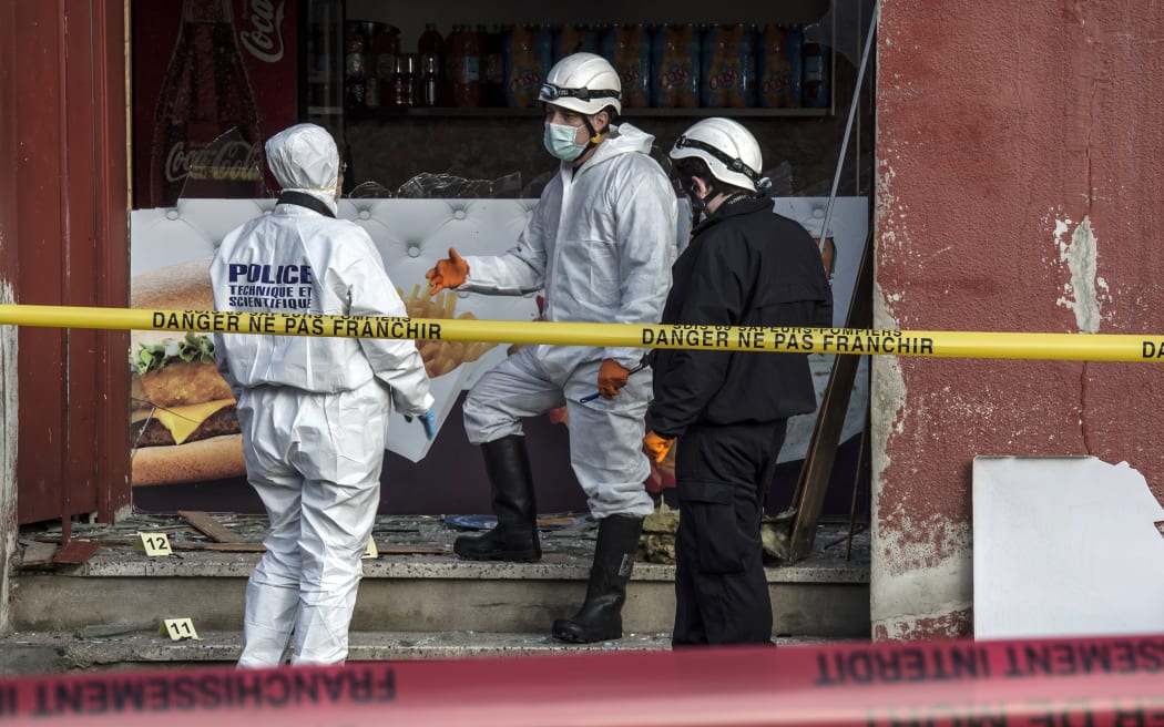 French police forensic scour the scene of an explosion at a kebab shop damaged following an explosion near a mosque in Villefranche-sur-Saone, eastern France.