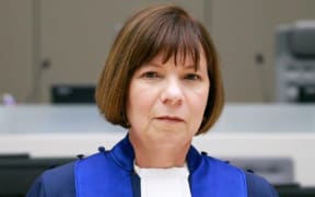 Woman with mid length straight dark hair in robes on International Criminal Court