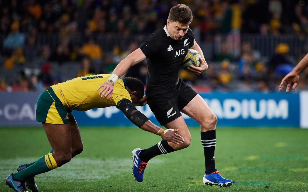 All Blacks first-five/fullback Beauden Barrett tries to evade a tackle by Australian winger Marika Koroibete.