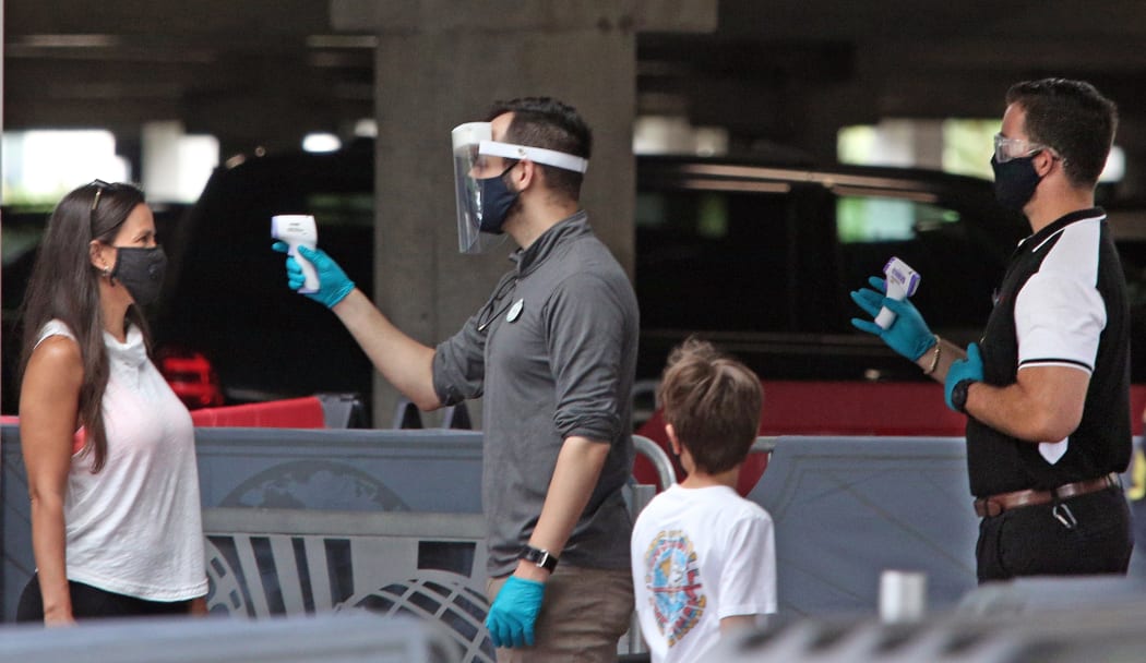 Visitors have their temperatures checked as they arrive at Universal Studios theme park on the first day of reopening after the shutdown during the coronavirus pandemic, on June 5, 2020, in Orlando, Florida.