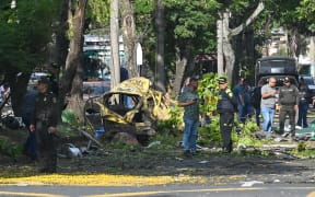 Members of the Colombian police inspect the area of a bomb explosion in cali, Colombia on August 21 2025. Five people were killed and dozens were injured when a vehicle bomb targeted a military base on a busy street in the Colombian city of Cali on August 21, 2025, local authorities said. (Photo by Oswaldo Páez / AFP)