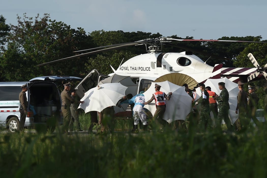 Police and military personnel around a helicopter at a Chiang Rai military air base on 9 July, when four more boys were rescued from a flooded cave.