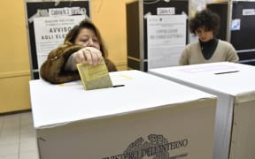 A woman votes at a polling station in central Rome.