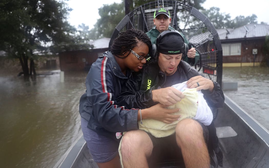 A three-week-old baby and her mother are rescued from the rising floodwaters.