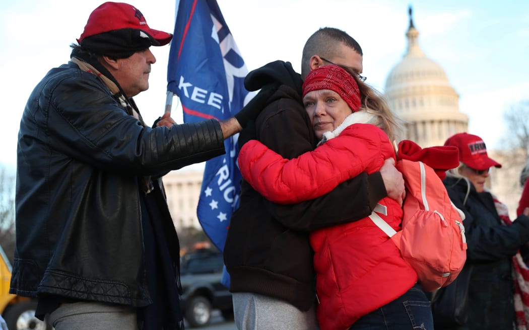 Gary Phaneuf, Tony Naples and Melody Black share a moment together as they visit a memorial setup near the U.S. Capitol Building for Ashli Babbitt who was killed in the building after a pro-Trump mob broke in on January 07, 2021 in Washington, DC.