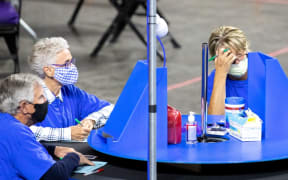 Contractors working for Cyber Ninjas, who was hired by the Arizona State Senate, examine and recount ballots from the 2020 general election at Veterans Memorial Coliseum 1 May, 2021 in Phoenix, Arizona.